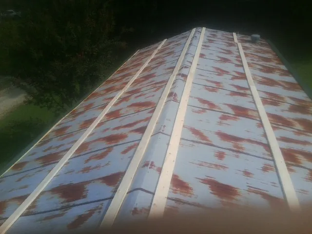 Rusted metal roof panels with new wood purlins before replacement — Storm Damage Roof Repair in Elkland by Roofing Brothers