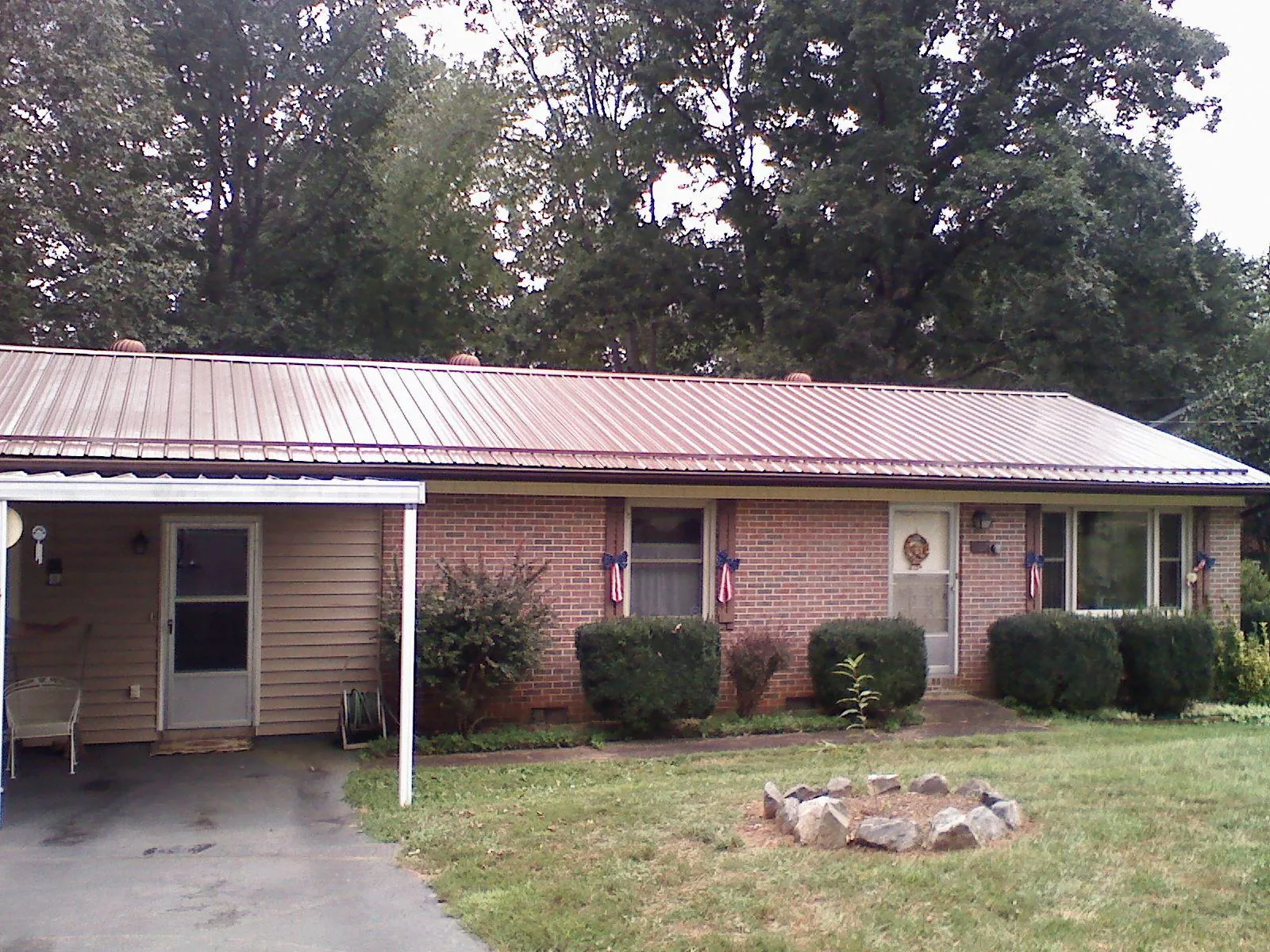Bronze metal roof and carport on a brick ranch home — Roof Repair work by our crew in Elkland